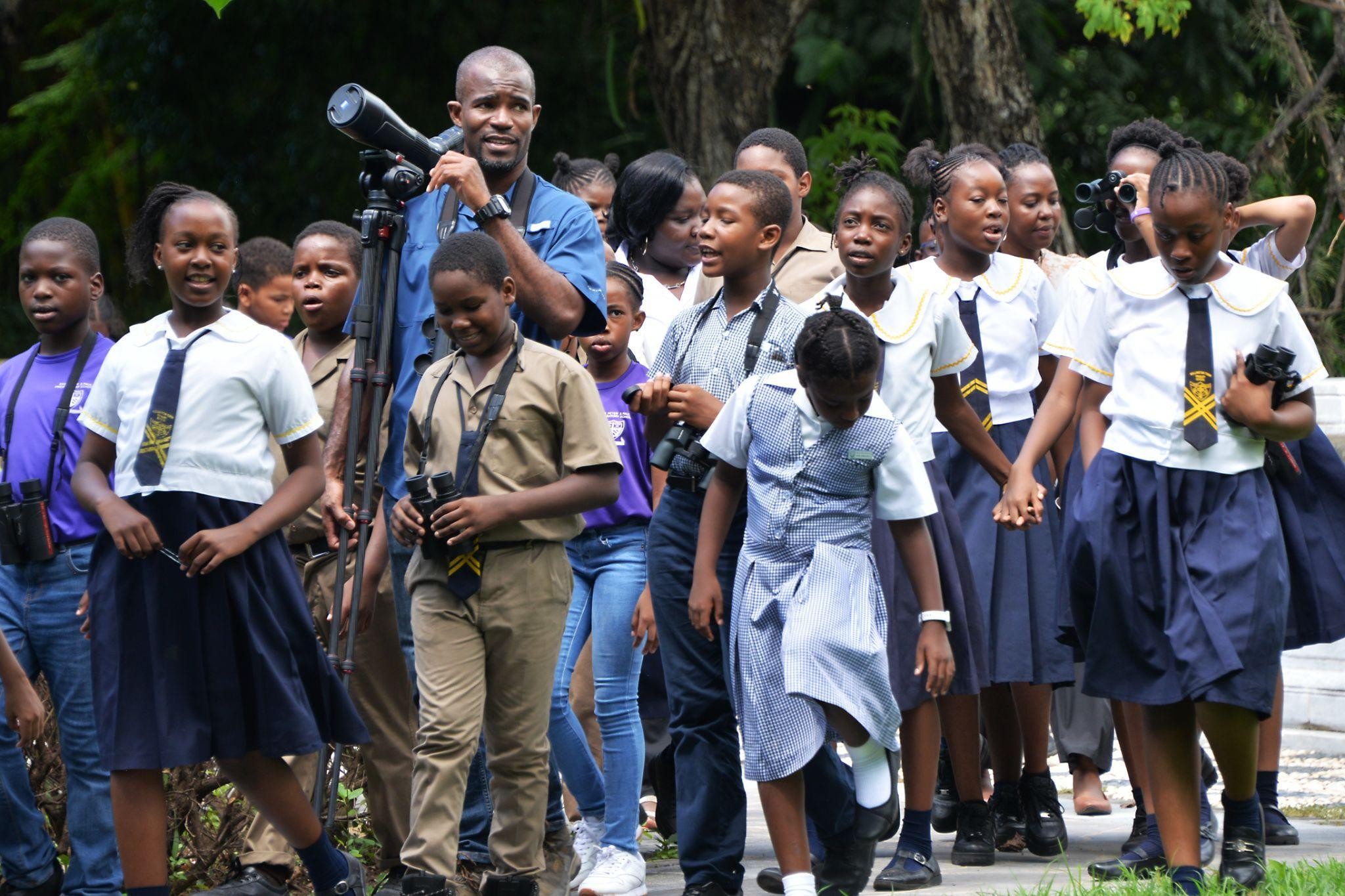 Mr. Ricardo Miller, Environmental Coordinator at the National Environment and Planning Agency (NEPA), and a member of BirdLife Jamaica engaging students of the Rollington Town Primary, Mona Preparatory School and Sts. Peter and Paul Preparatory School in a birding watching activity for World Migratory Birds Day.